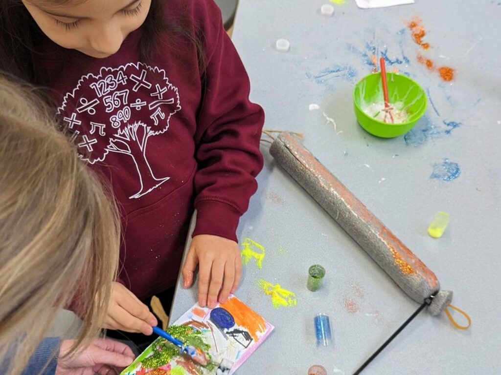 A child assembling a model at a Space Club table